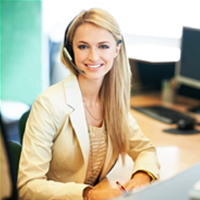 This is a picture of a receptionist sitting at her desk smiling at the camera.