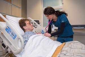 This is a picture of a nurse listening to a elderly lady&apos;s breath sounds