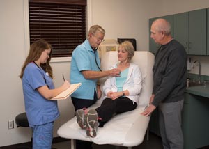 This is a picture of a doctor listening to a elderly lady's breath sounds